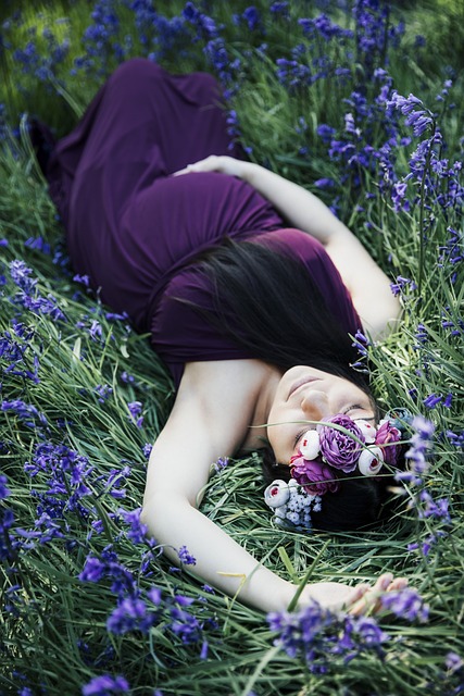 woman in purple dress laying in purple flowers