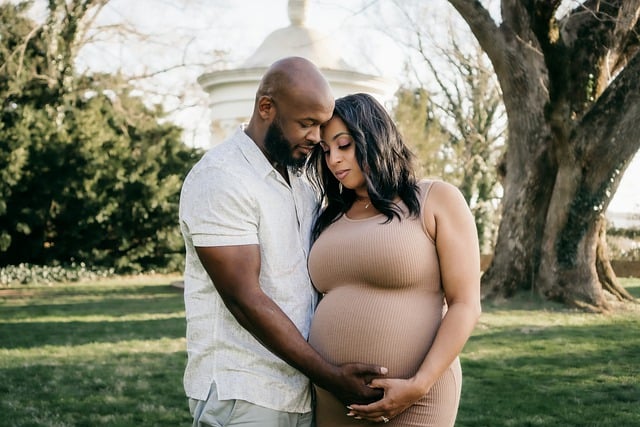 man and woman with dark skin holding her pregnant belly