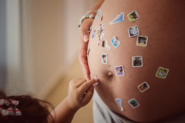 baby placing stickers on moms belly