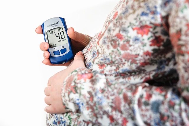 pregnant woman holding up a device which measures Basel body temperature